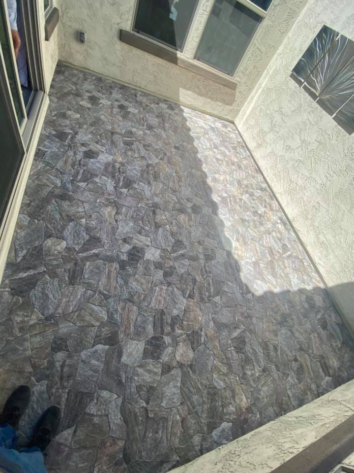 A person is standing on a tiled floor in a room.