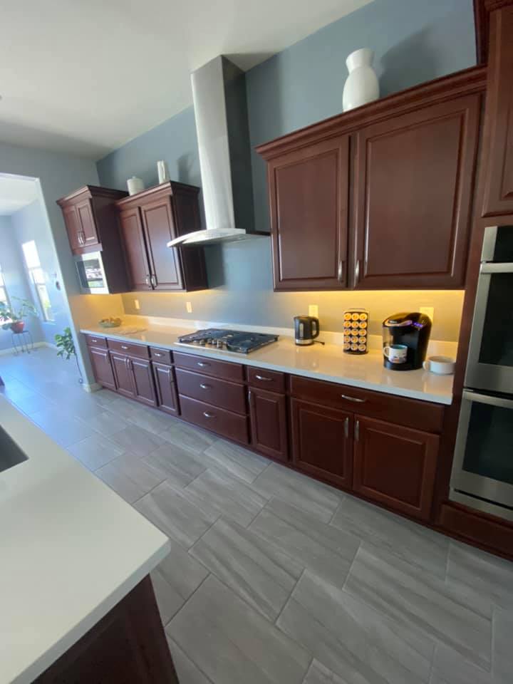 A kitchen with wooden cabinets , a stove top oven , and a coffee maker.