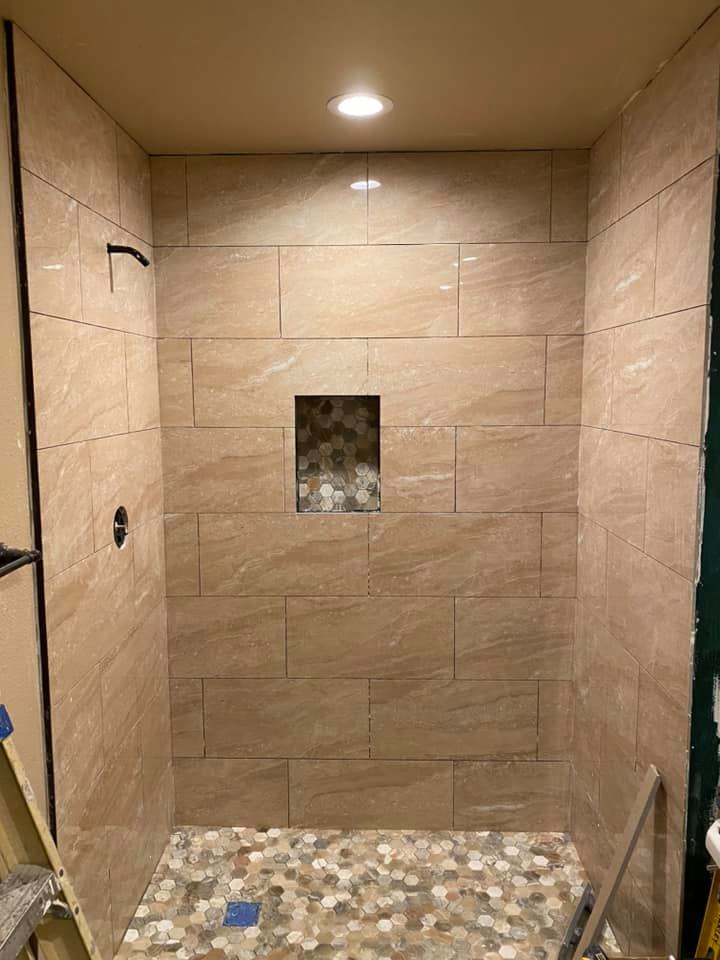 A shower stall with tiled walls and a tiled floor.