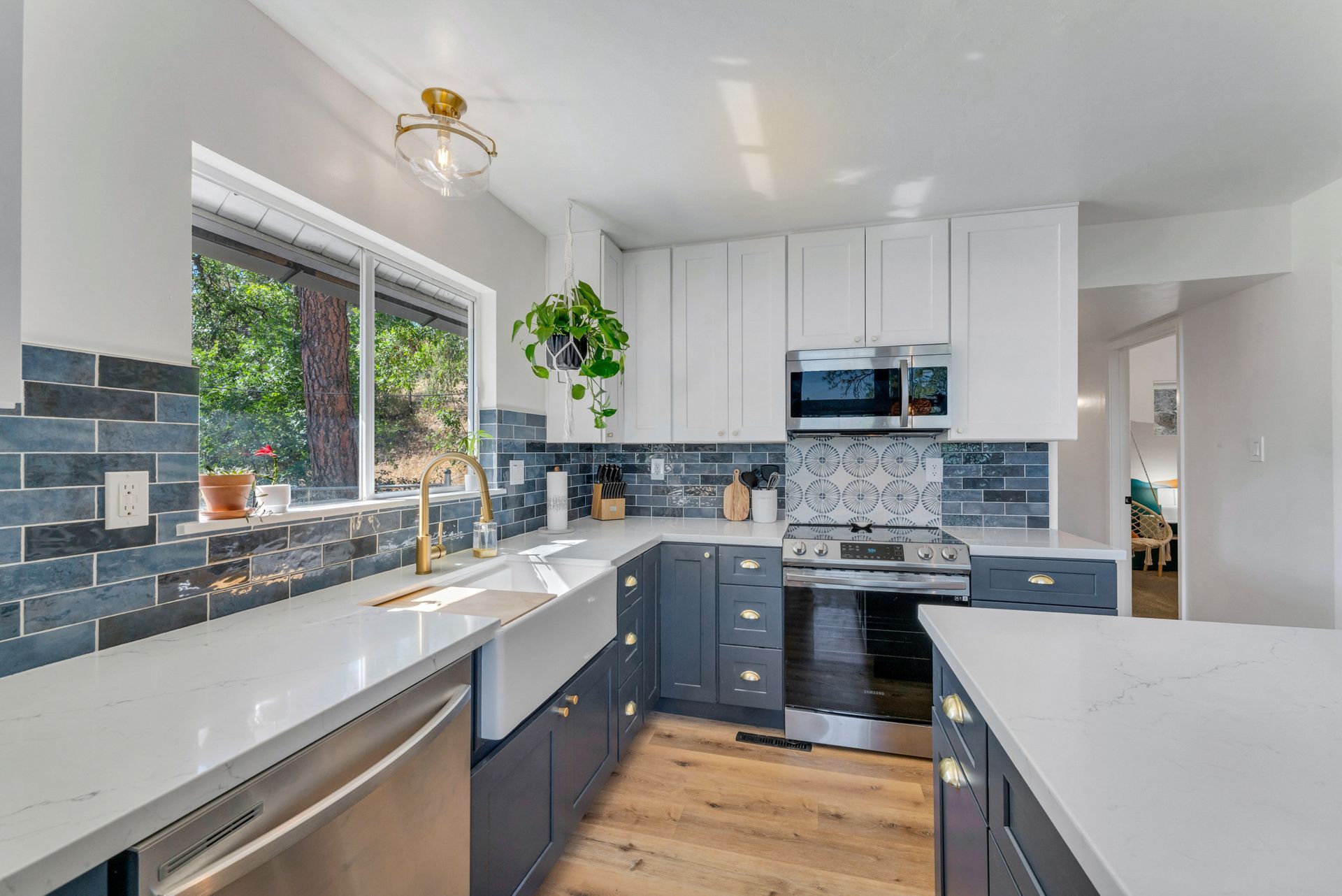 A kitchen with stainless steel appliances , a sink , and a window.