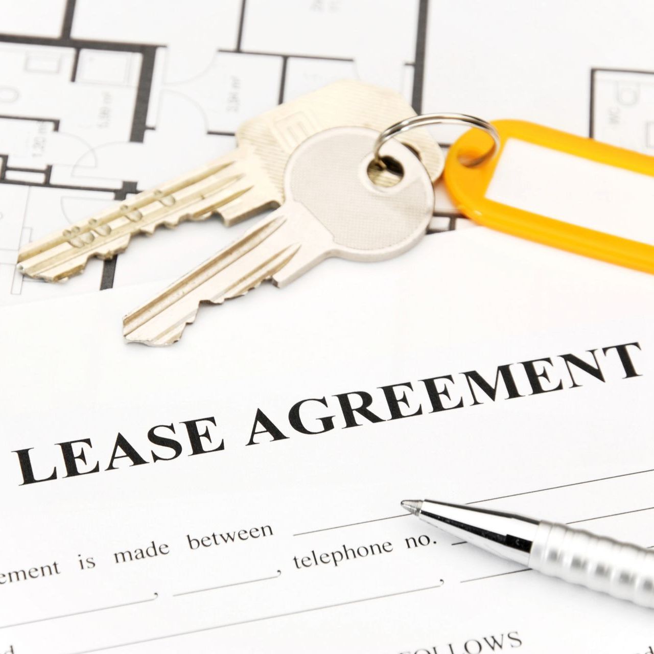 A lease agreement with keys and a pen on it