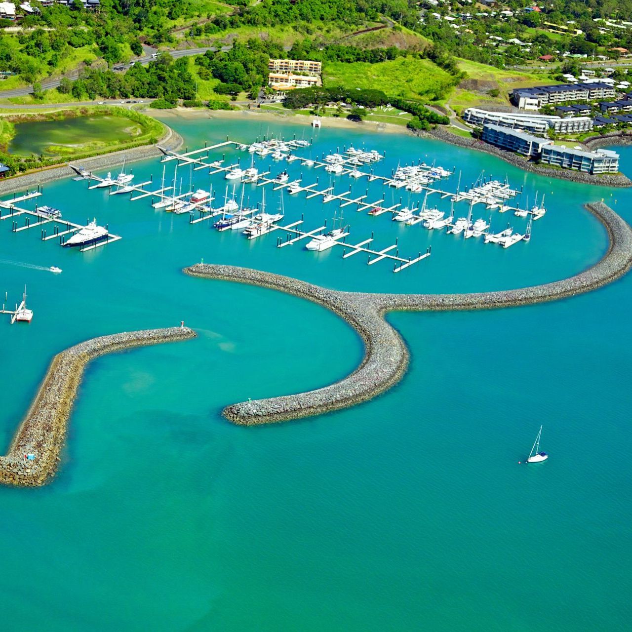 An aerial view of a marina with boats docked in the water.