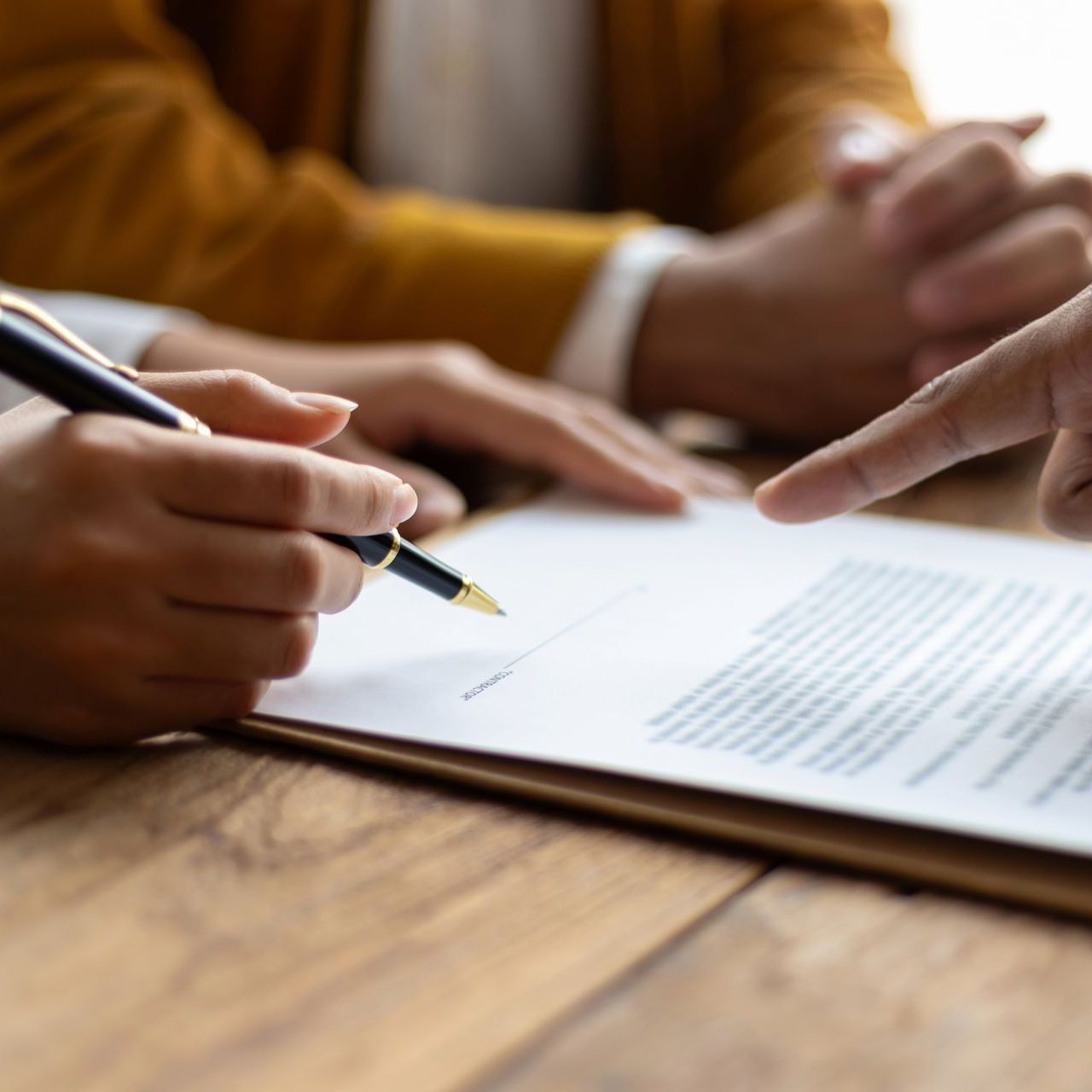 A person is writing on a piece of paper with a pen.