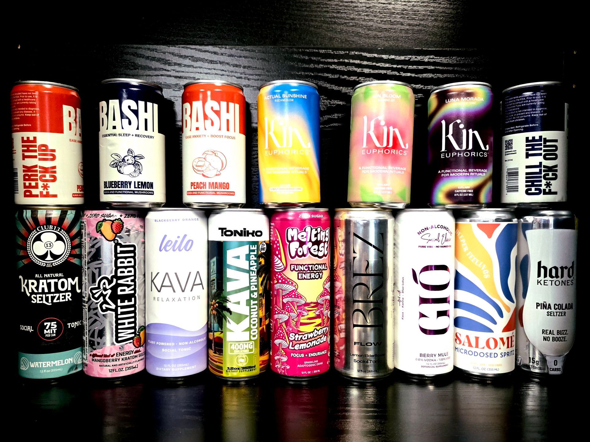 Two rows of various colorful canned drinks arranged against a black background.