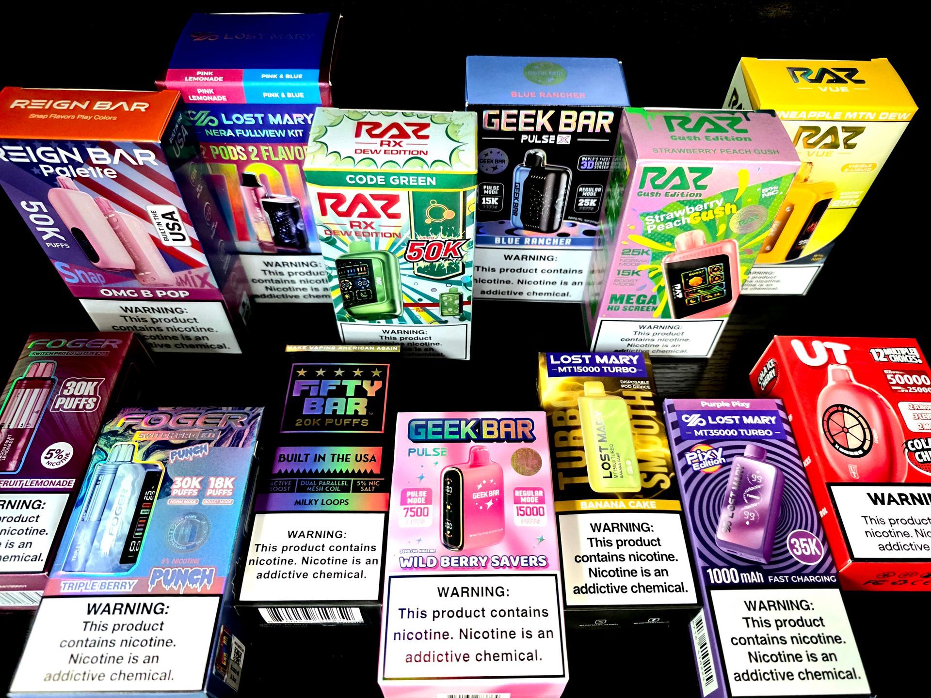 An array of colorful boxes for various brands of disposable electronic nicotine delivery devices on a black background.