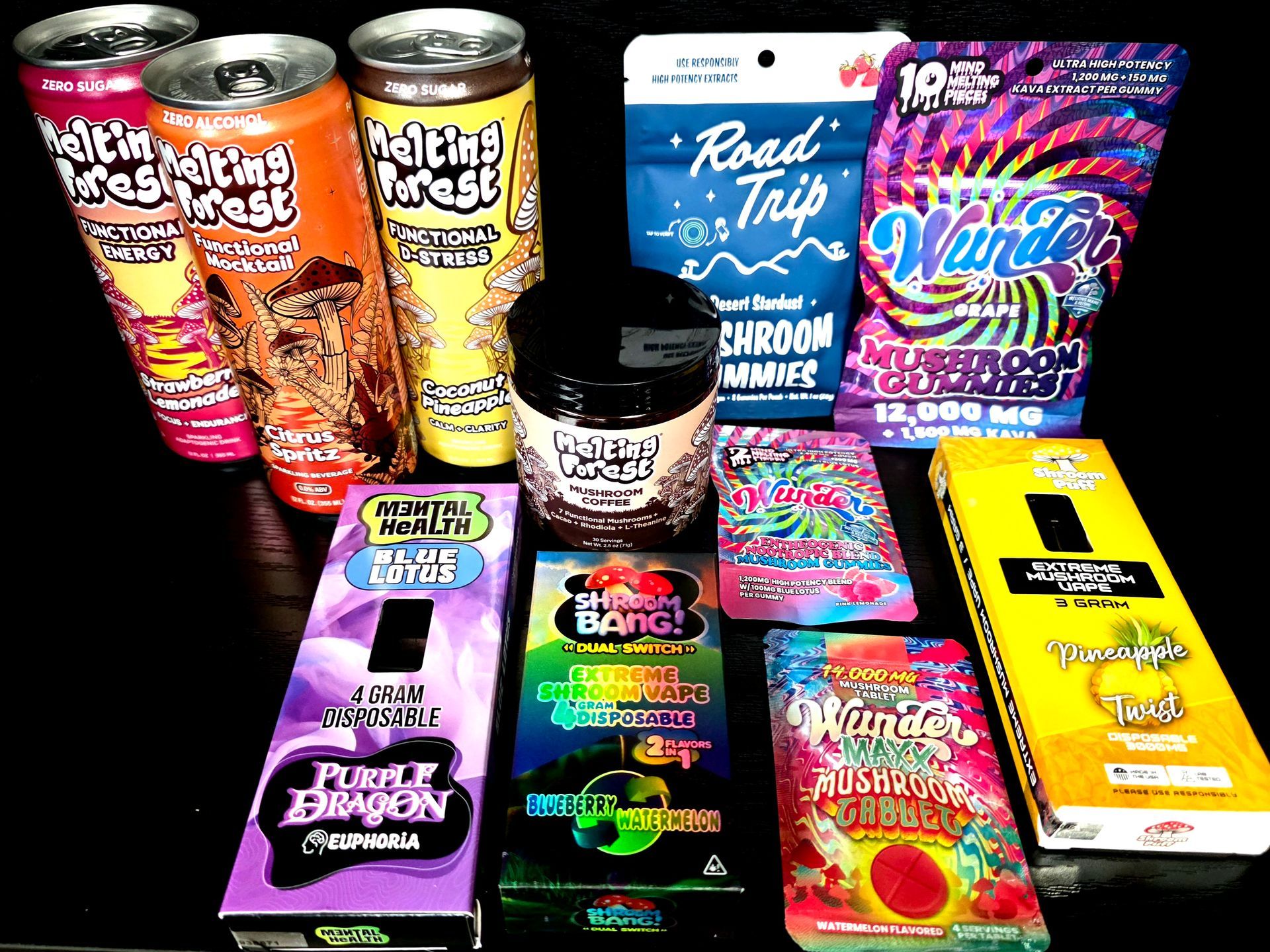 A collection of various brightly colored, branded mushroom-themed beverage cans, chocolate bar boxes, and gummy pouches.