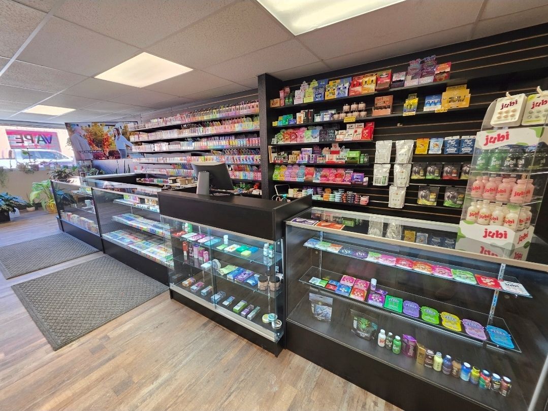 Interior view of a smoke or vape shop featuring glass display cases and wall shelves stocked with assorted products.