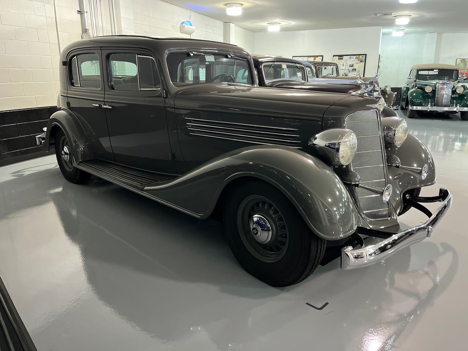 Dark gray vintage car in a bright garage.