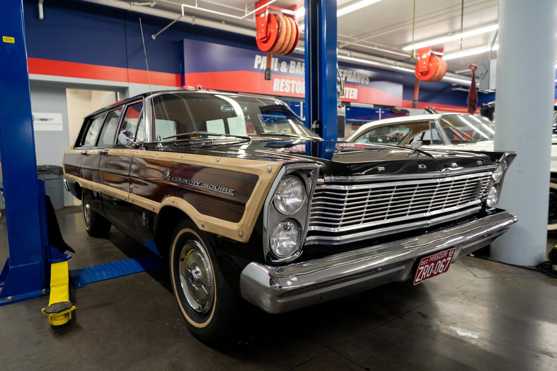 Black vintage station wagon with wood paneling in a museum