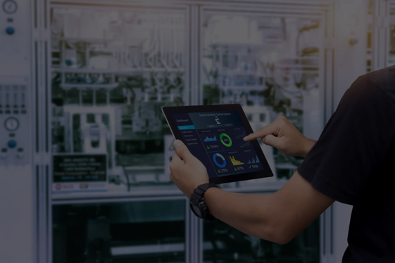 Person using a tablet to monitor equipment, likely in a data center or industrial setting.