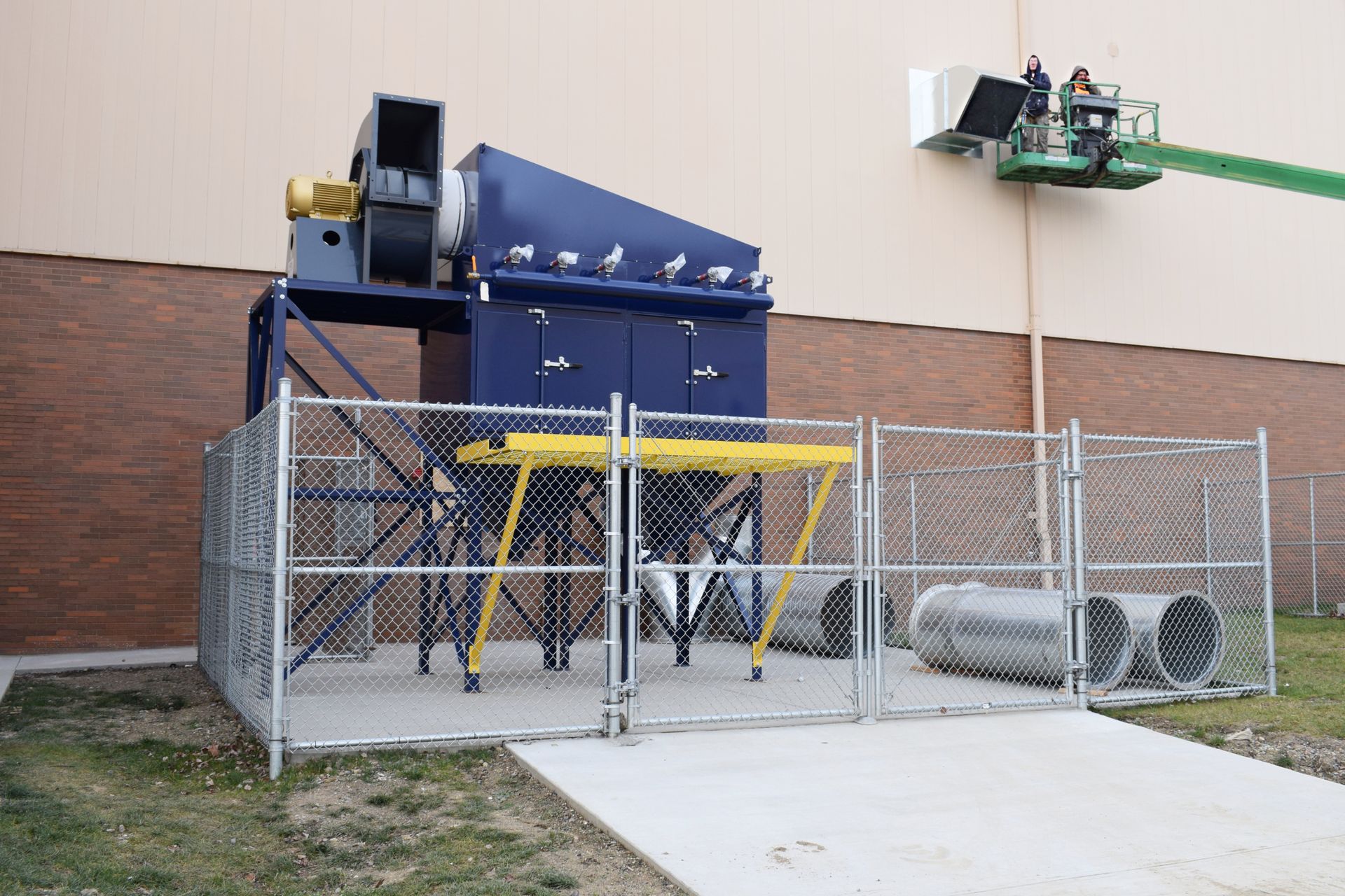 Outdoor dust collector installation with fenced work area