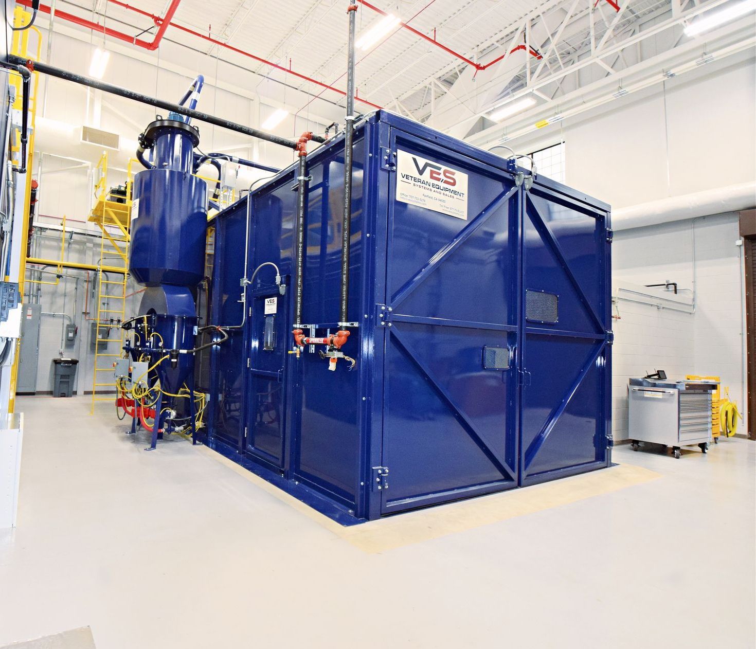 Blue industrial machine in a brightly lit room, likely for manufacturing or research.