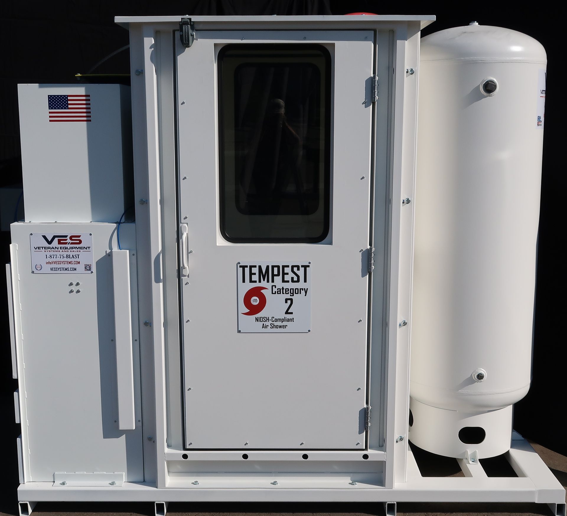 White Tempest 2 shelter with door, window, and tank on a metal base, against a dark backdrop.