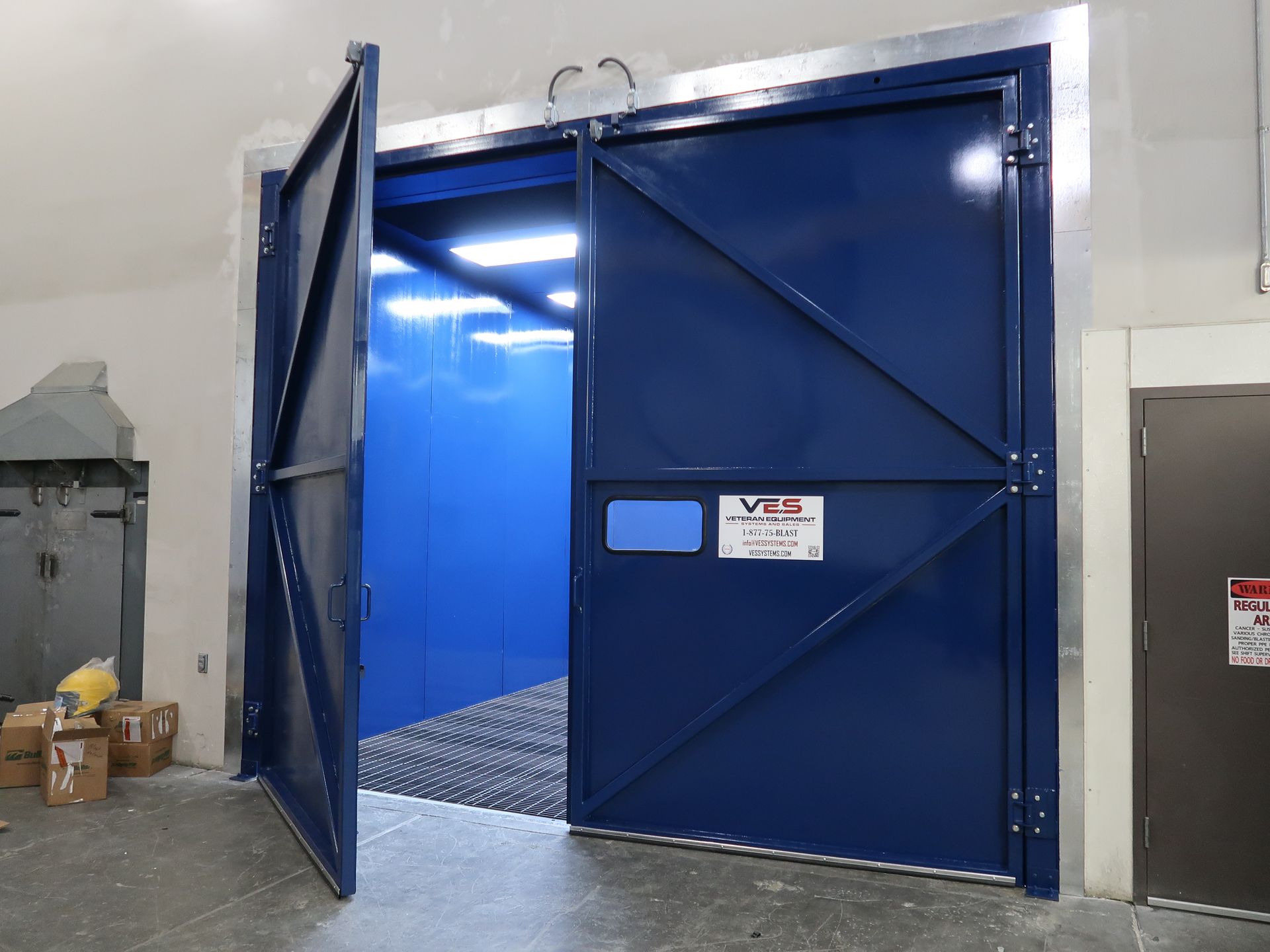Blue industrial lift doors open in a warehouse.