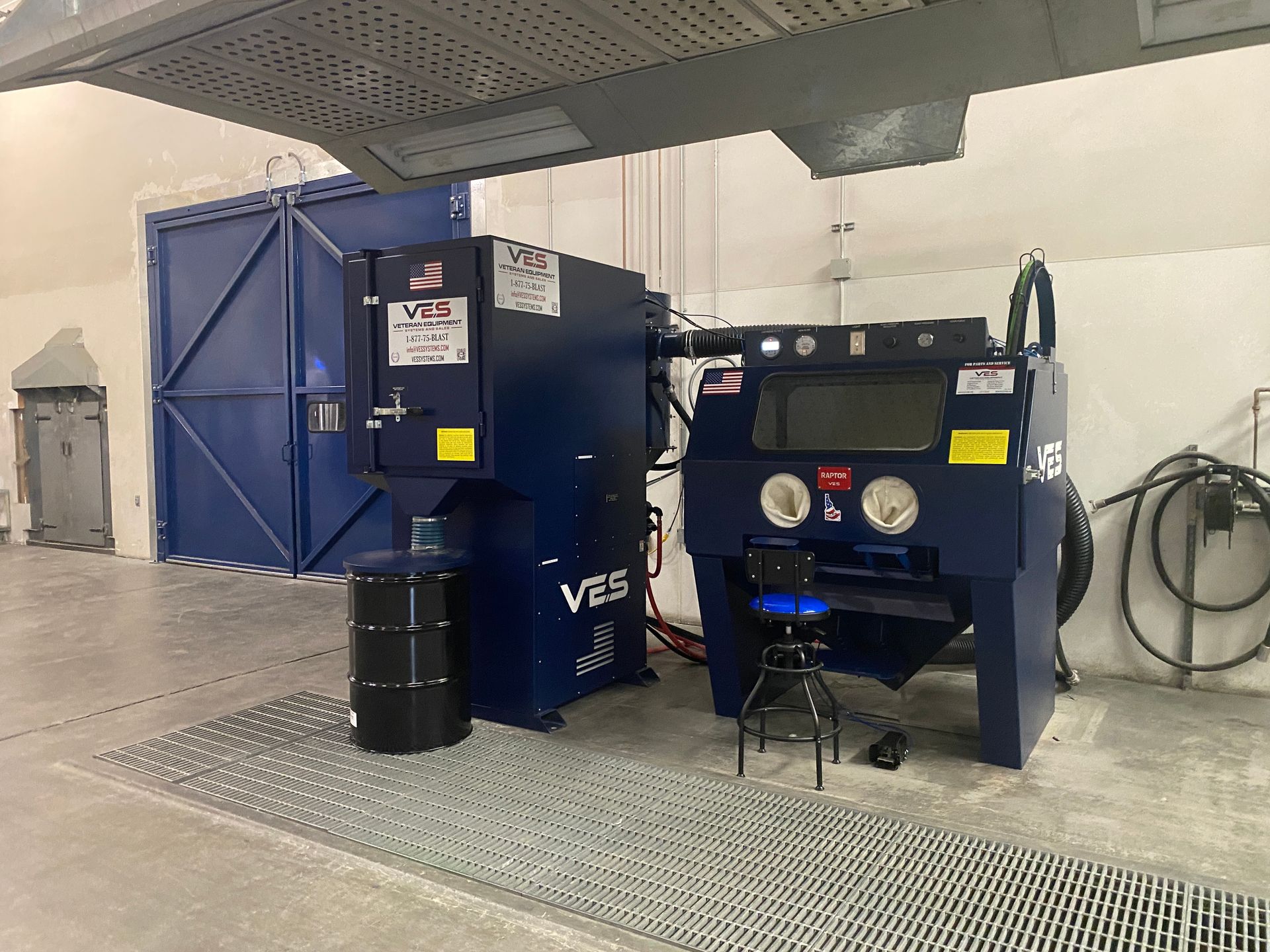 Blue industrial sandblasting equipment in a workshop.