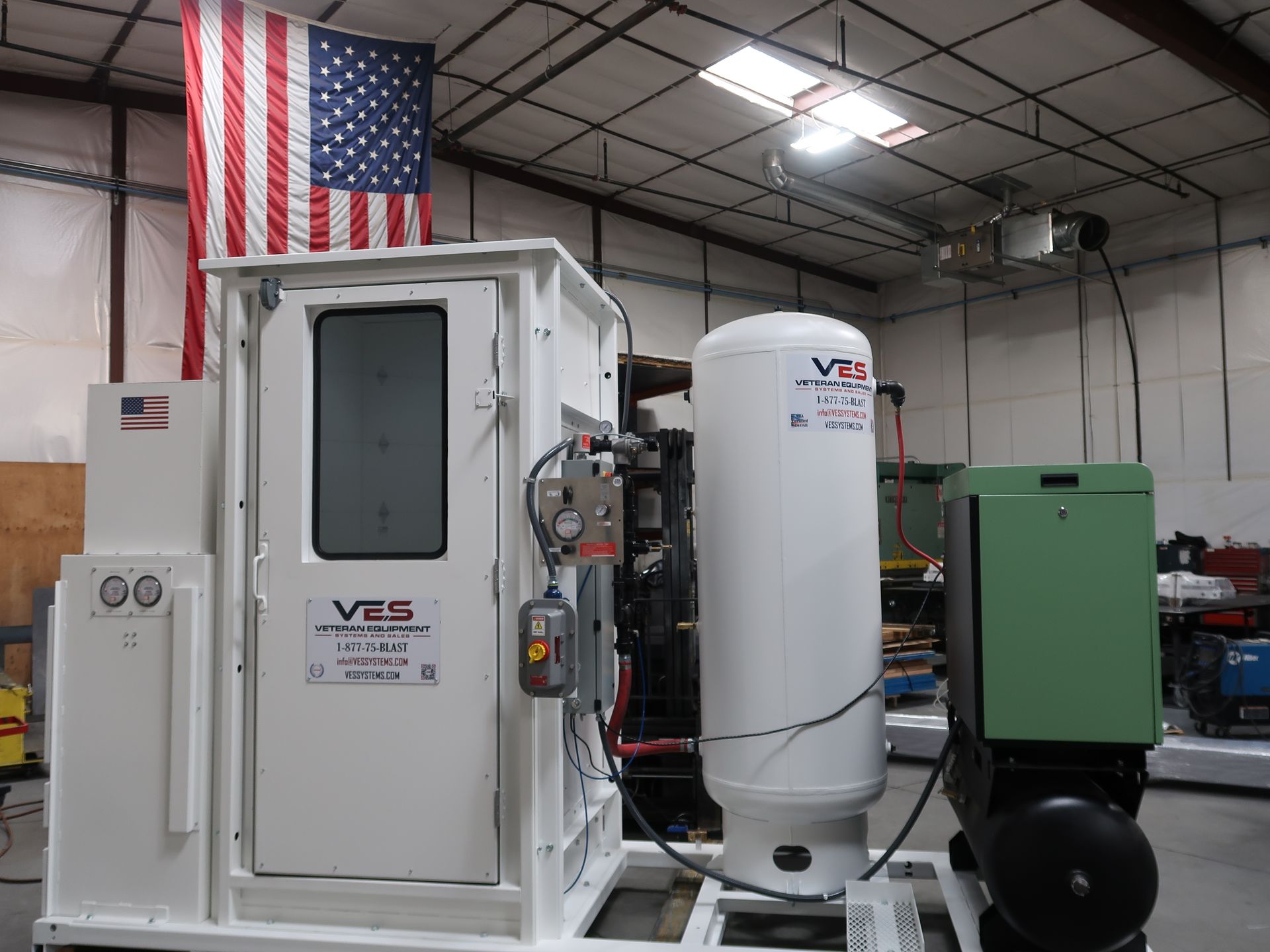 White industrial machine with an American flag in a factory.