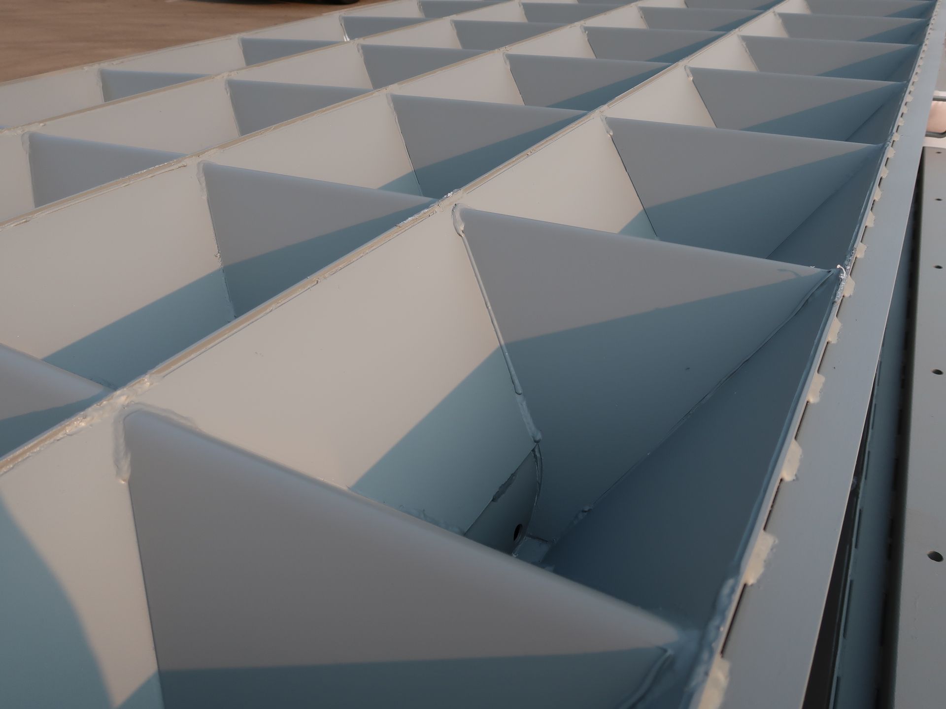 Light blue, compartmentalized structure with triangular dividers, likely for storage or organization.