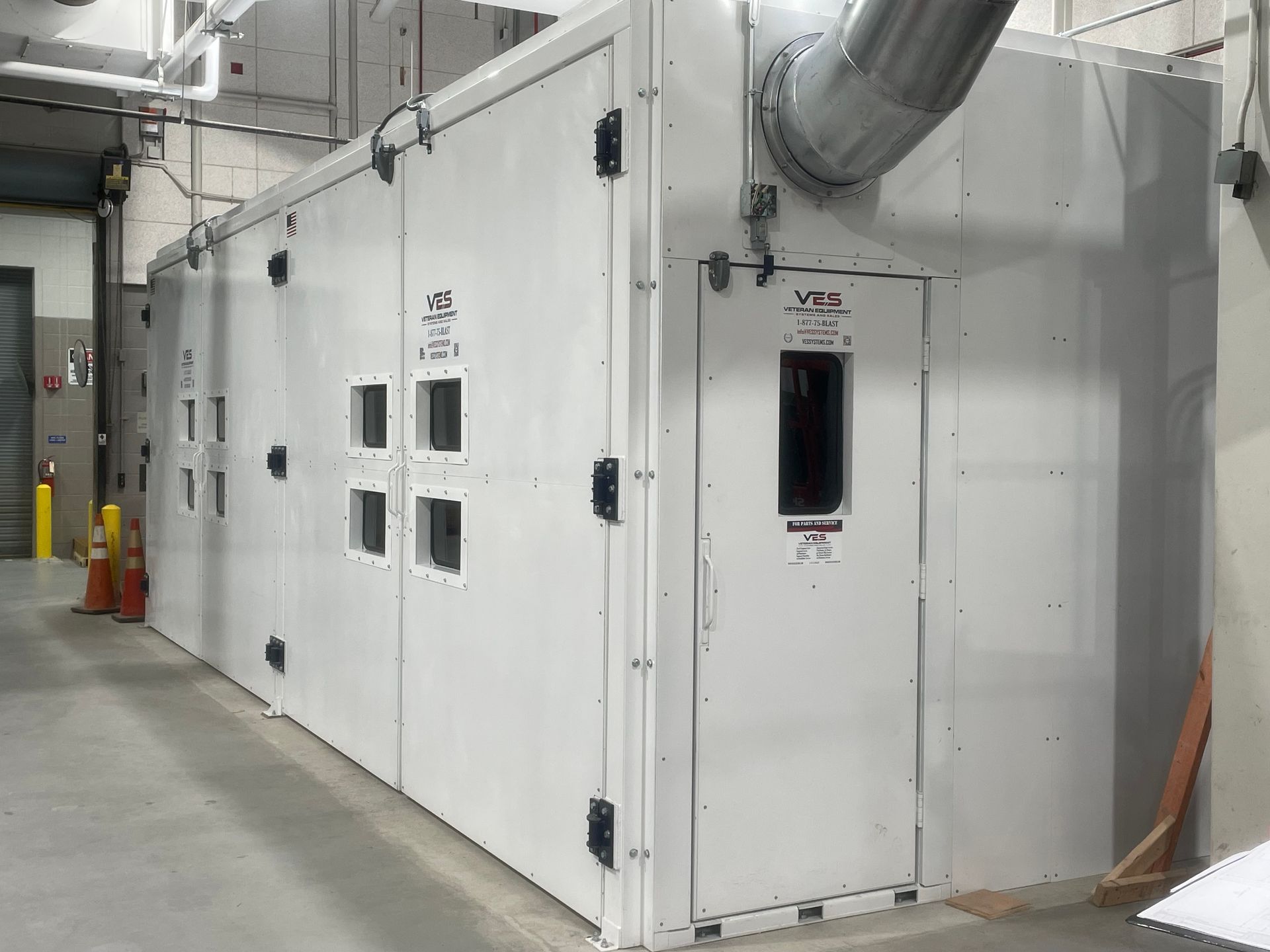 White industrial sound booth in a factory setting.