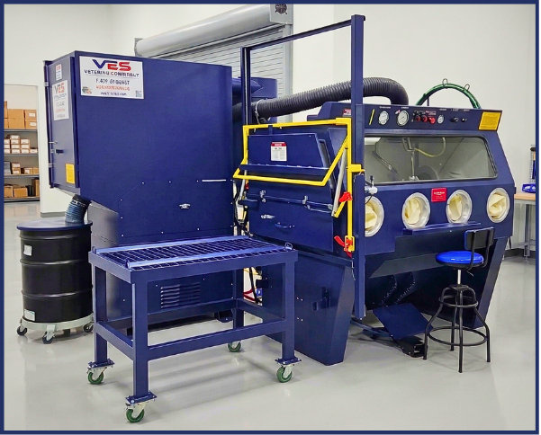 VES Raptor blast cabinet with dust collector, yellow platform, and industrial work area setup.