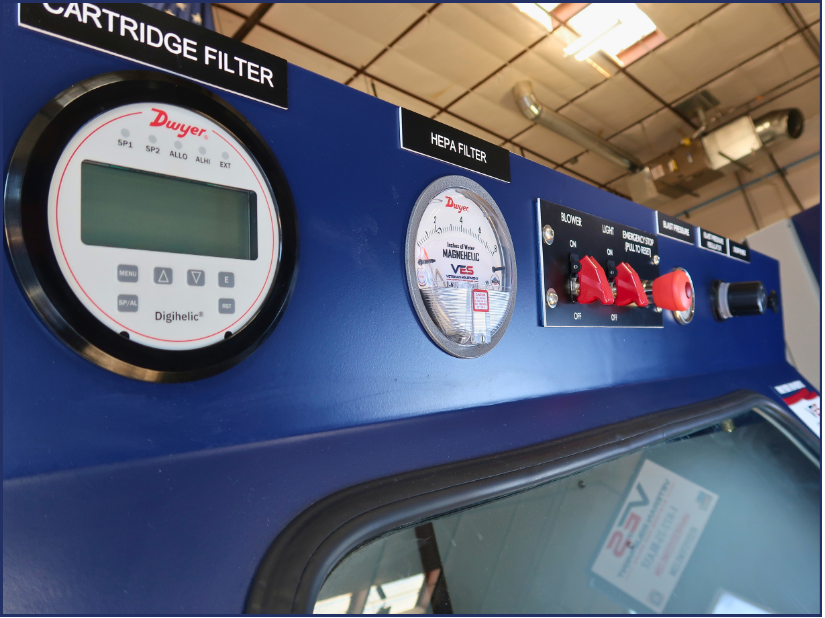 Close-up of VES Raptor blast cabinet gauges, controls, and cartridge filter pressure display.
