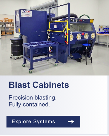 Industrial blue blast cabinet with attached dust collector system in a manufacturing facility.