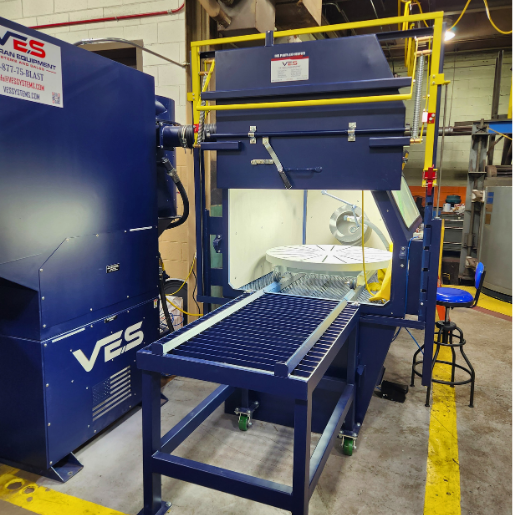 VES blast cabinet system with front work platform, safety railing, and integrated dust collection equipment in an industrial facility