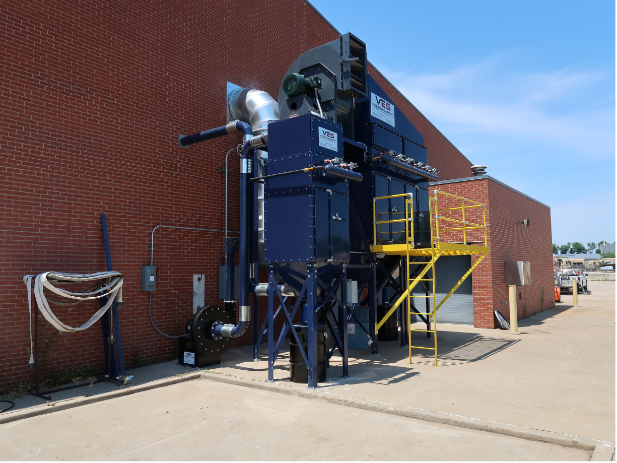 Outdoor dust collection system installed beside industrial facility