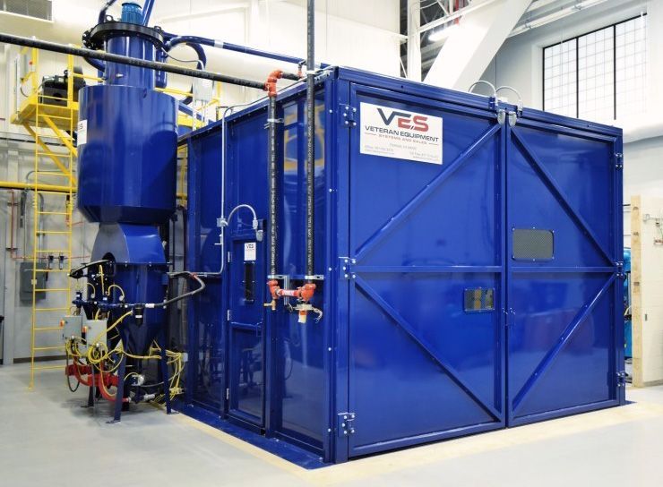 Blue industrial machine in a lab; V ES logo.