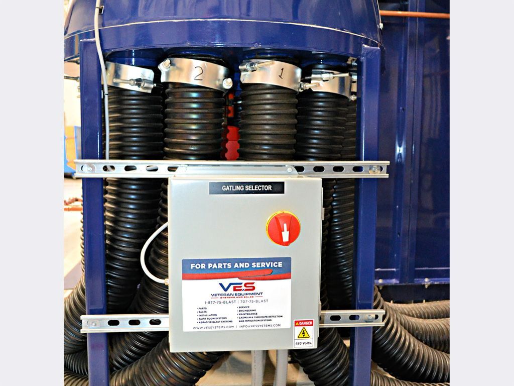 Blue industrial equipment with black hoses, control panel, and metal ductwork.