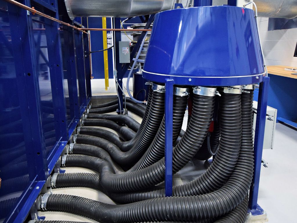 Blue industrial machine with multiple black hoses connected to a central hub.
