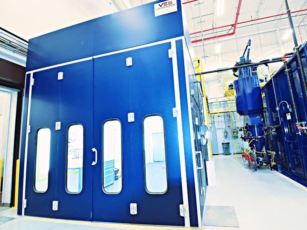 Blue automotive paint booth in a workshop.