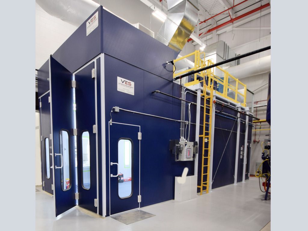 Blue paint booth in a factory setting. Includes doors, windows, and access ladder.