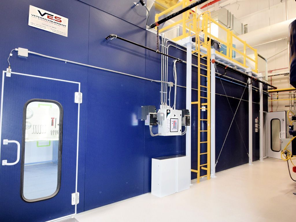 Blue industrial room with doorway, machinery, and elevated platform.