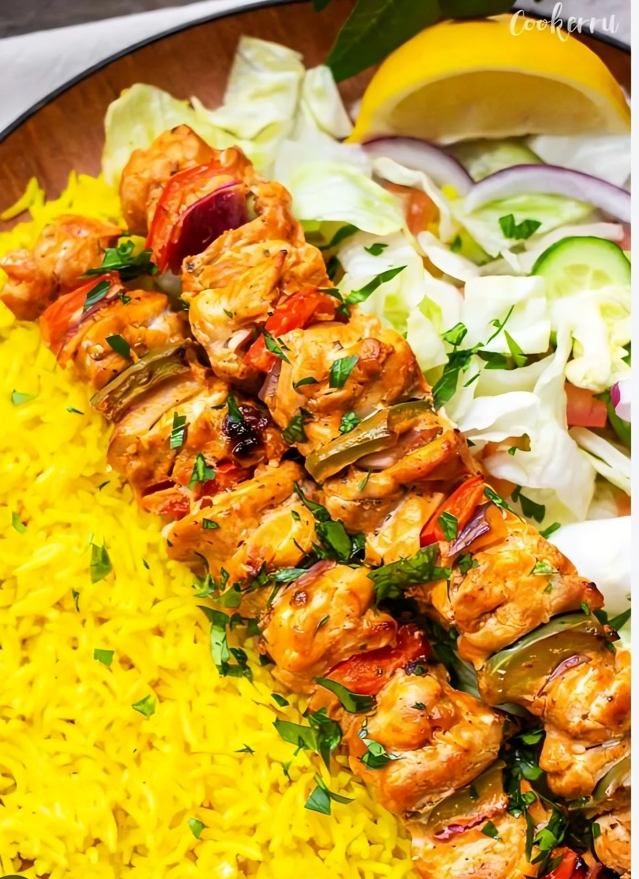 Chicken kebabs with yellow rice and salad.