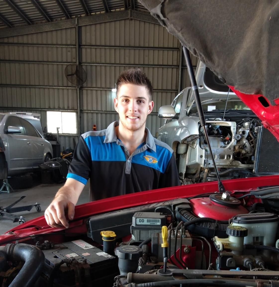 A Man Is Standing In Front Of A Car With The Hood Open — Mareeba Motors In Mareeba, QLD