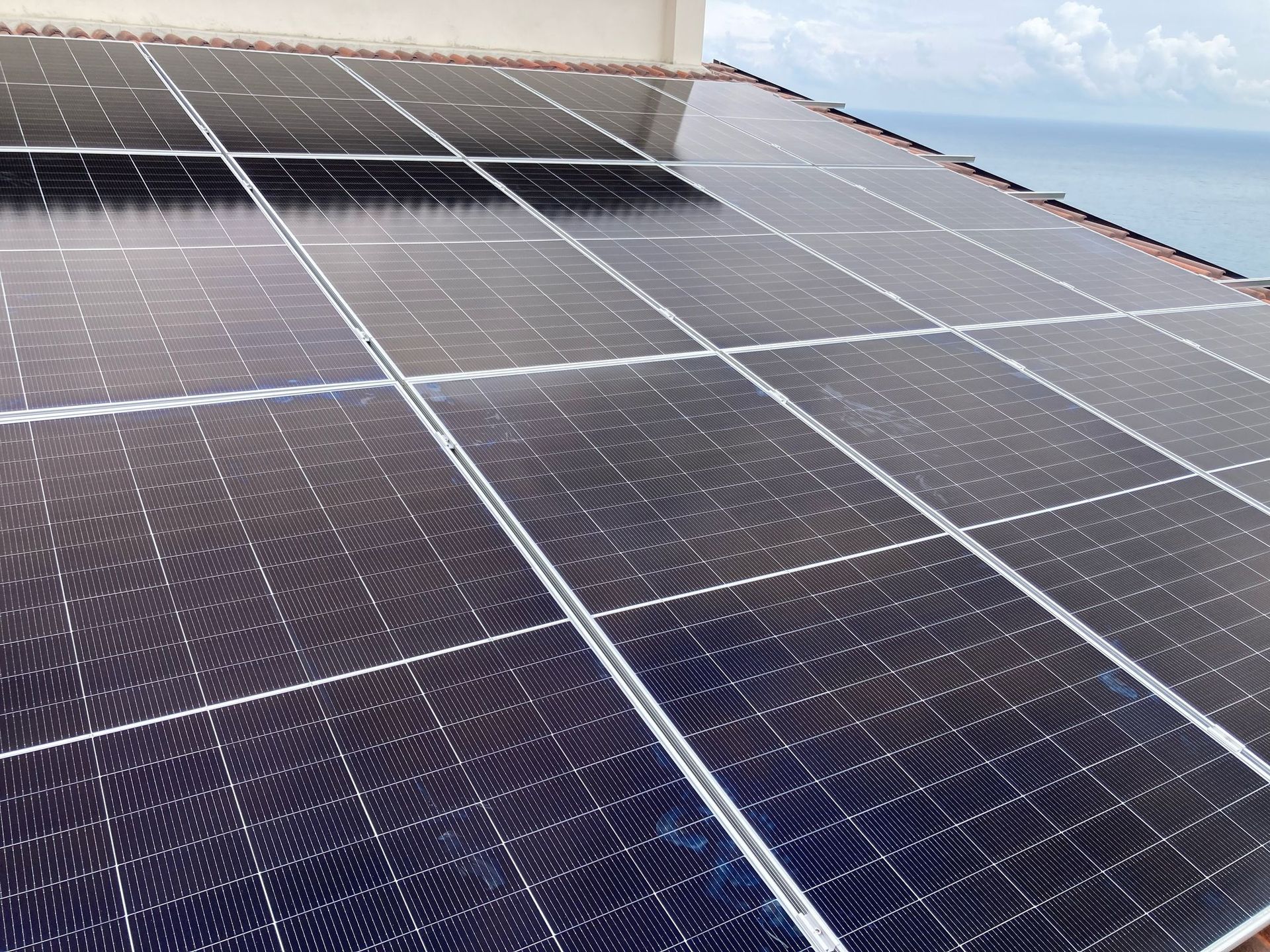 Ci sono molti pannelli solari sul tetto di un edificio.