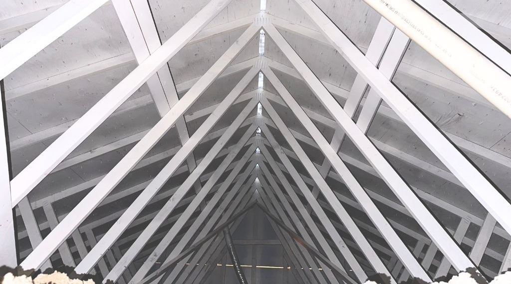 White wooden rafters forming a triangular roof structure.