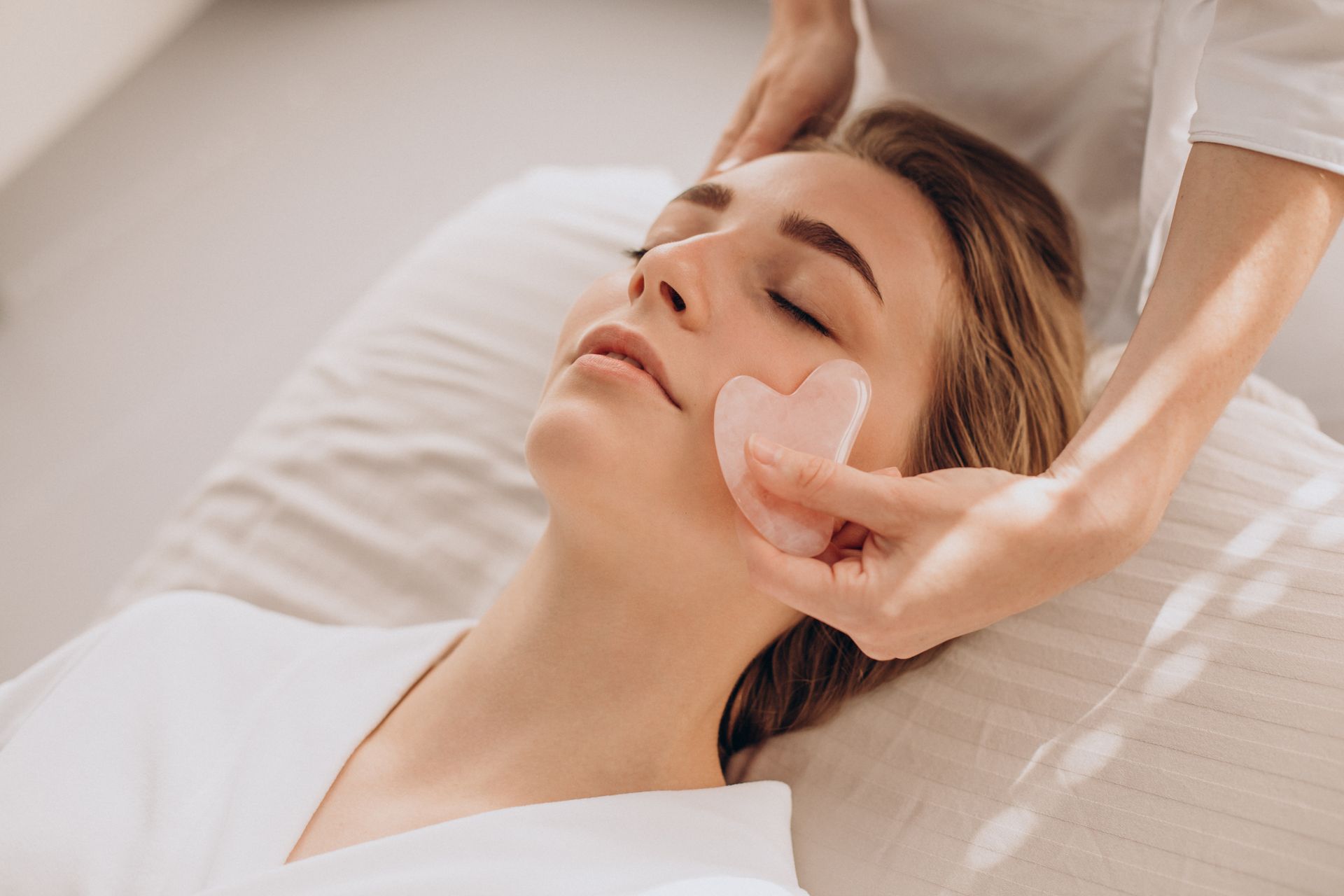 A woman is getting a renewal facial massage at a spa.