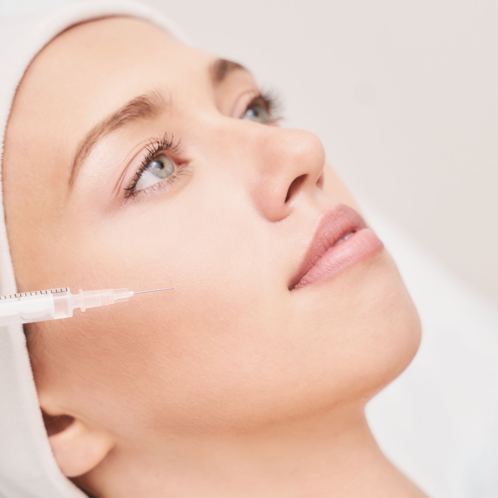 A close up of a woman getting an injection in her face