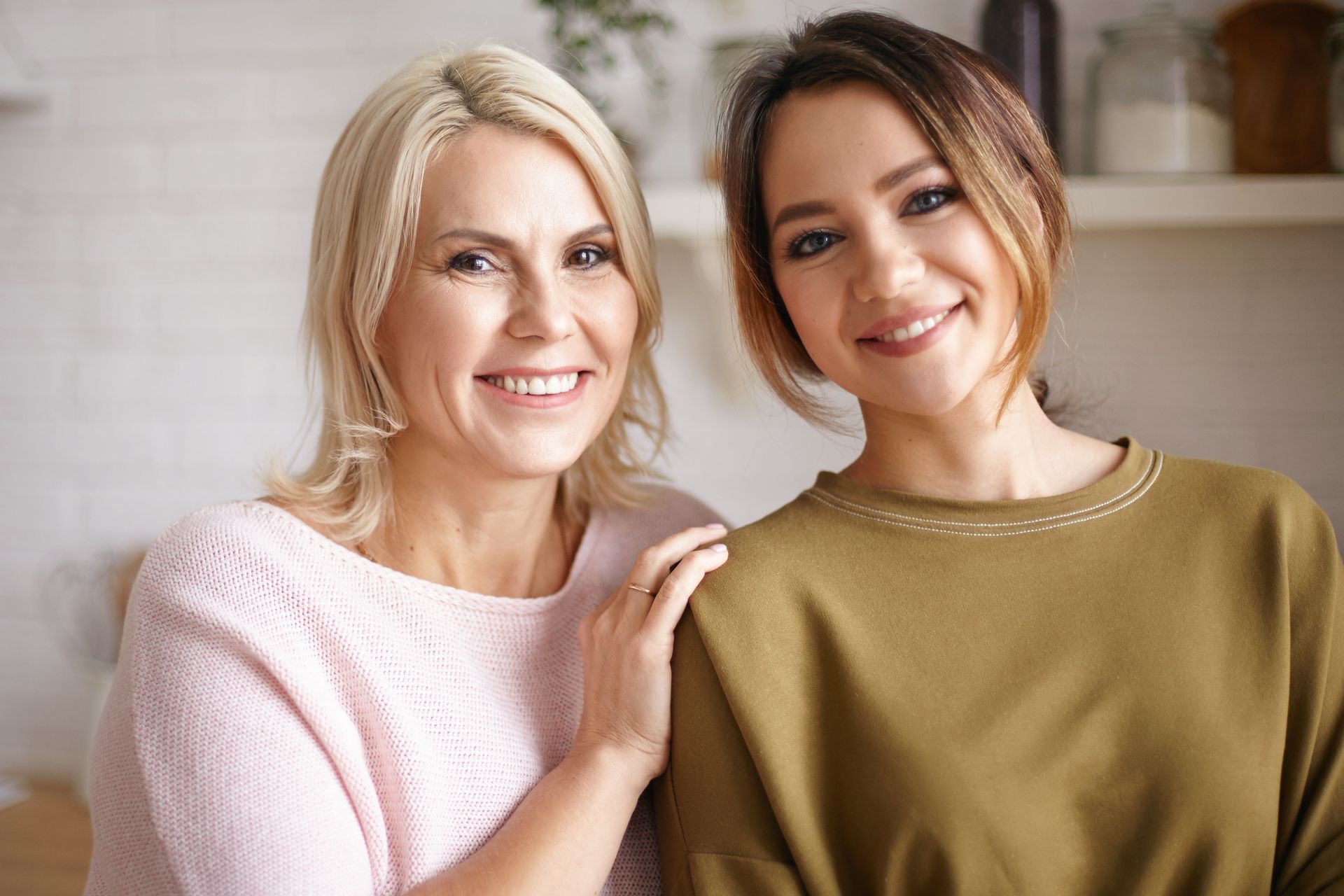Two women are posing for a picture together and smiling for the camera.