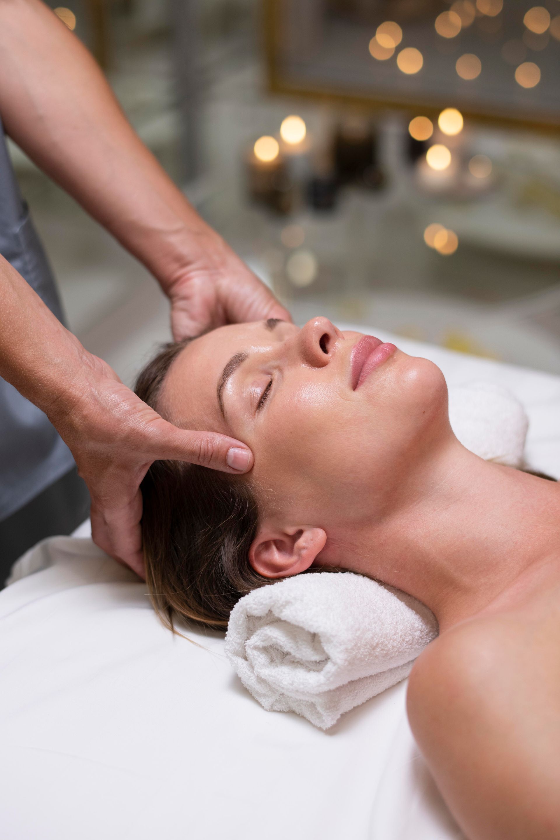 A woman is getting a head massage at a spa.