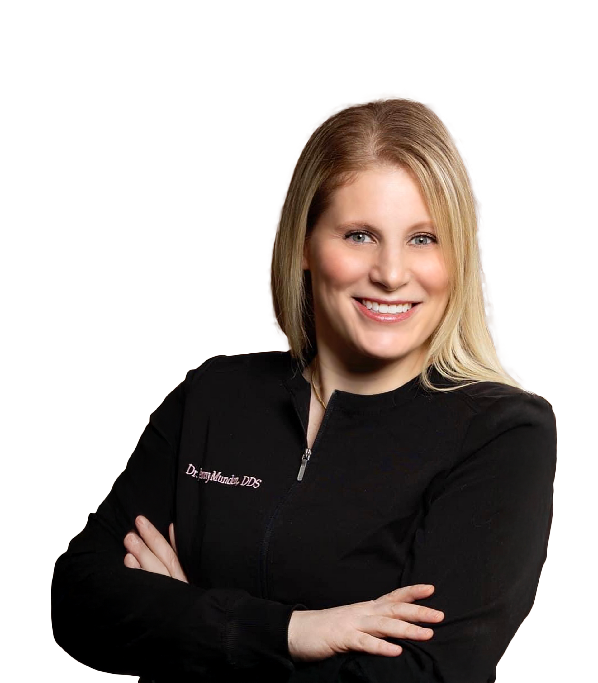 Woman with blonde hair smiling, wearing a black zip-up jacket, arms crossed.