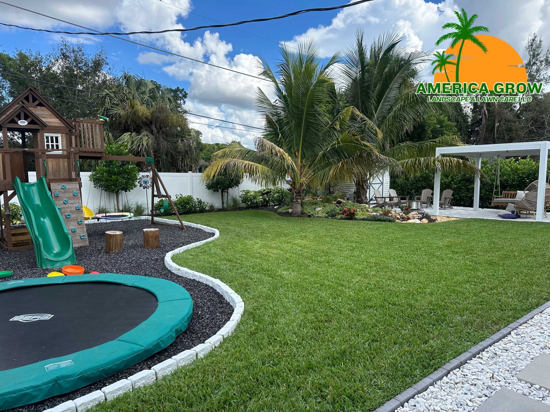 Backyard with playset, trampoline, grass, and pergola on a sunny day.