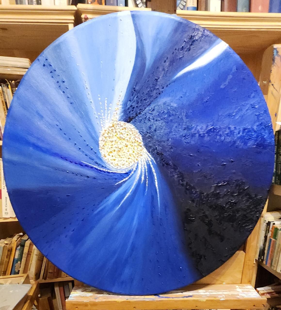 Cuadro abstracto redondo con tonos azules y blancos, centro texturizado como una estrella.