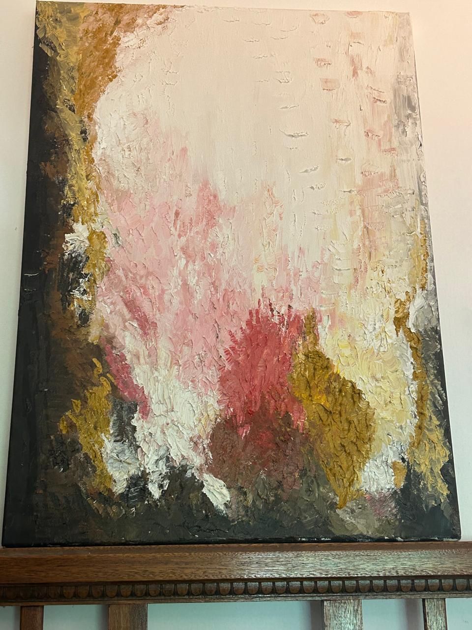 Cuadro abstracto con pinceladas blancas, rosas, marrones y doradas sobre fondo oscuro.