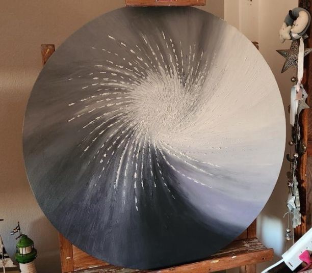 Pintura circular abstracta con un centro en espiral, que pasa del gris oscuro al blanco.