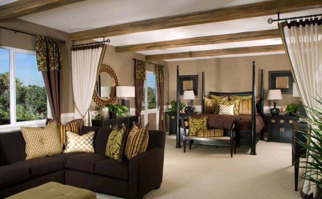 Spacious living room with brown sofas, cream curtains, wood beams, and tropical views through open windows