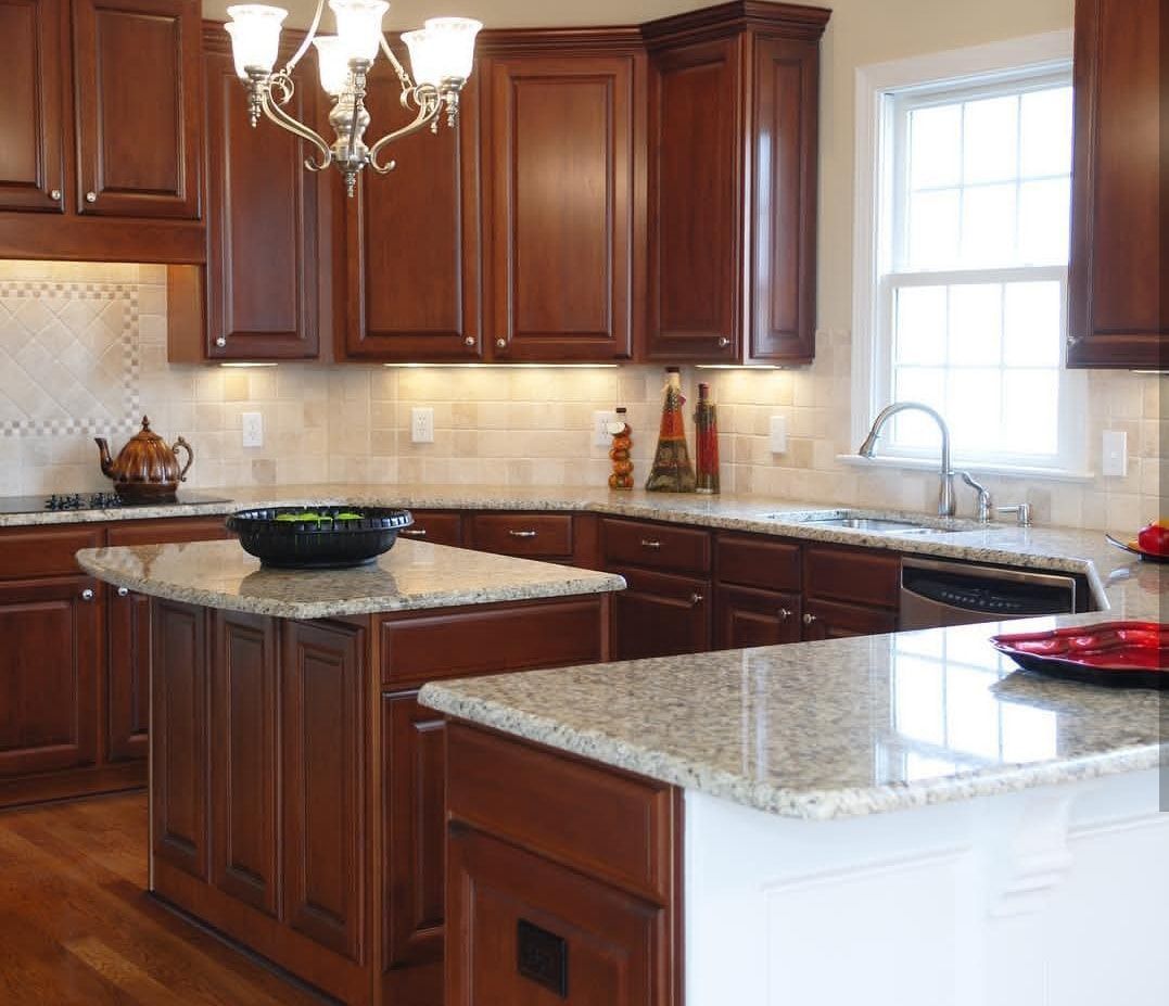 Modern kitchen with dark wood cabinets, granite countertops, island, and window over the sink