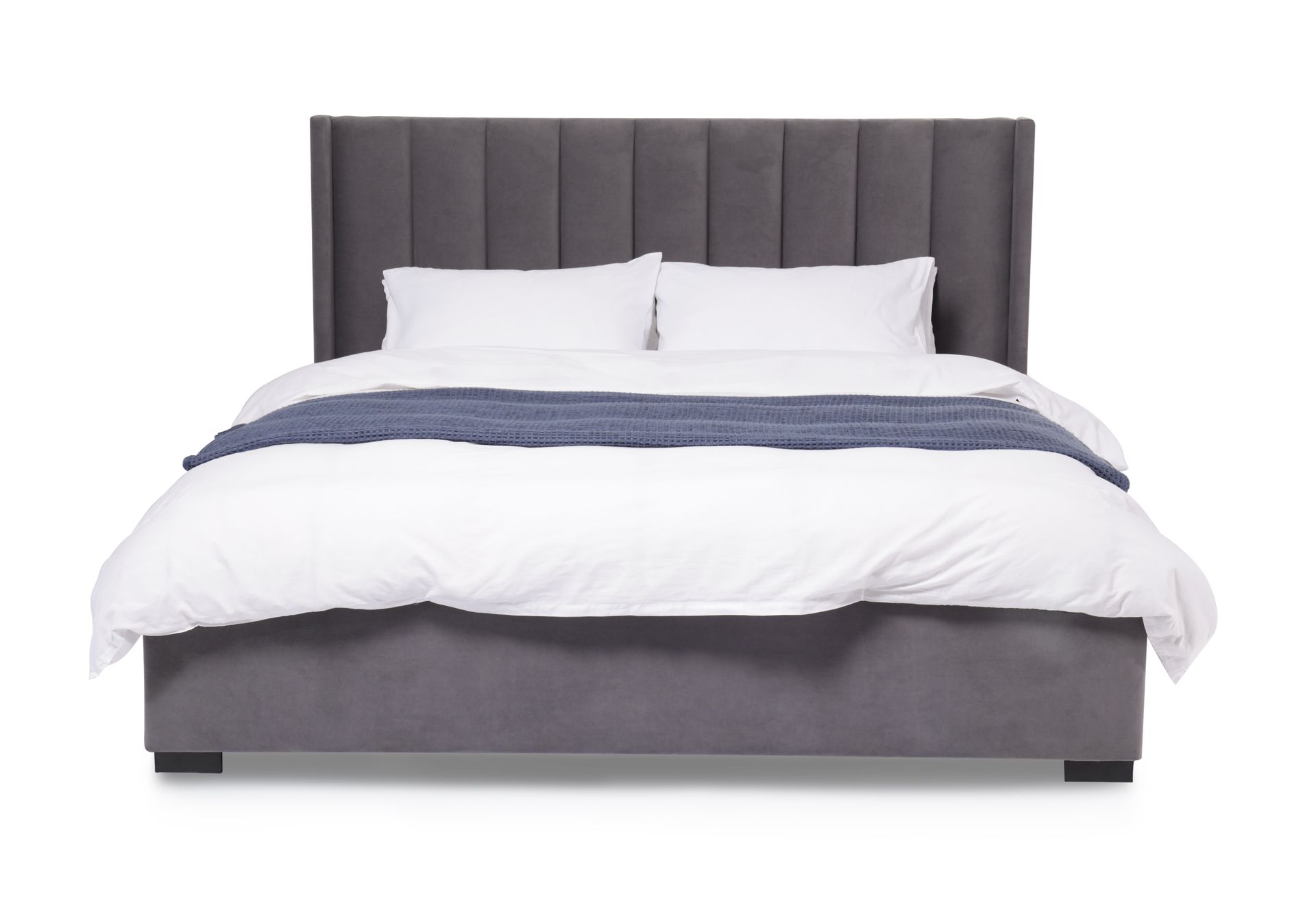 Gray upholstered bed with white bedding and a tall tufted headboard