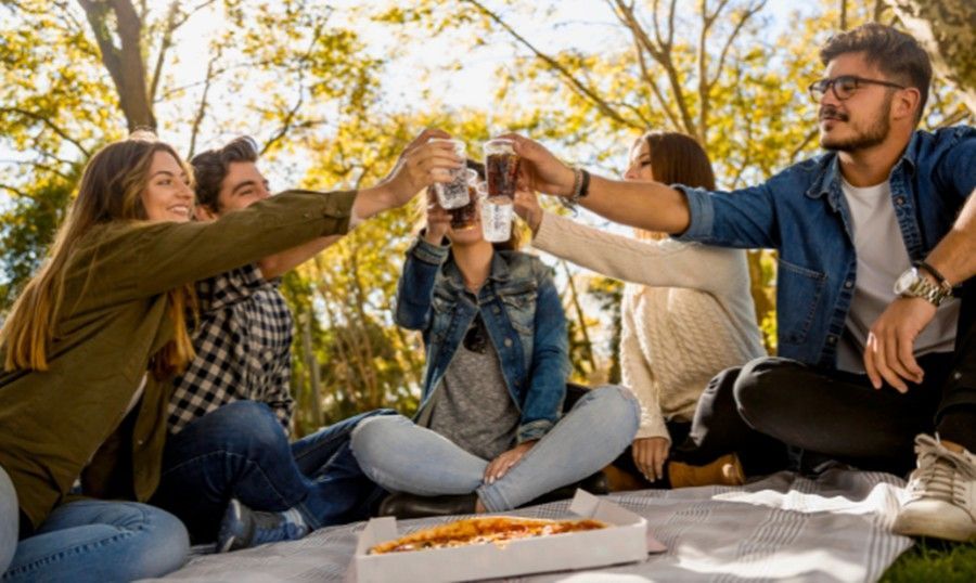 A group of young people are having a picnic in the park.